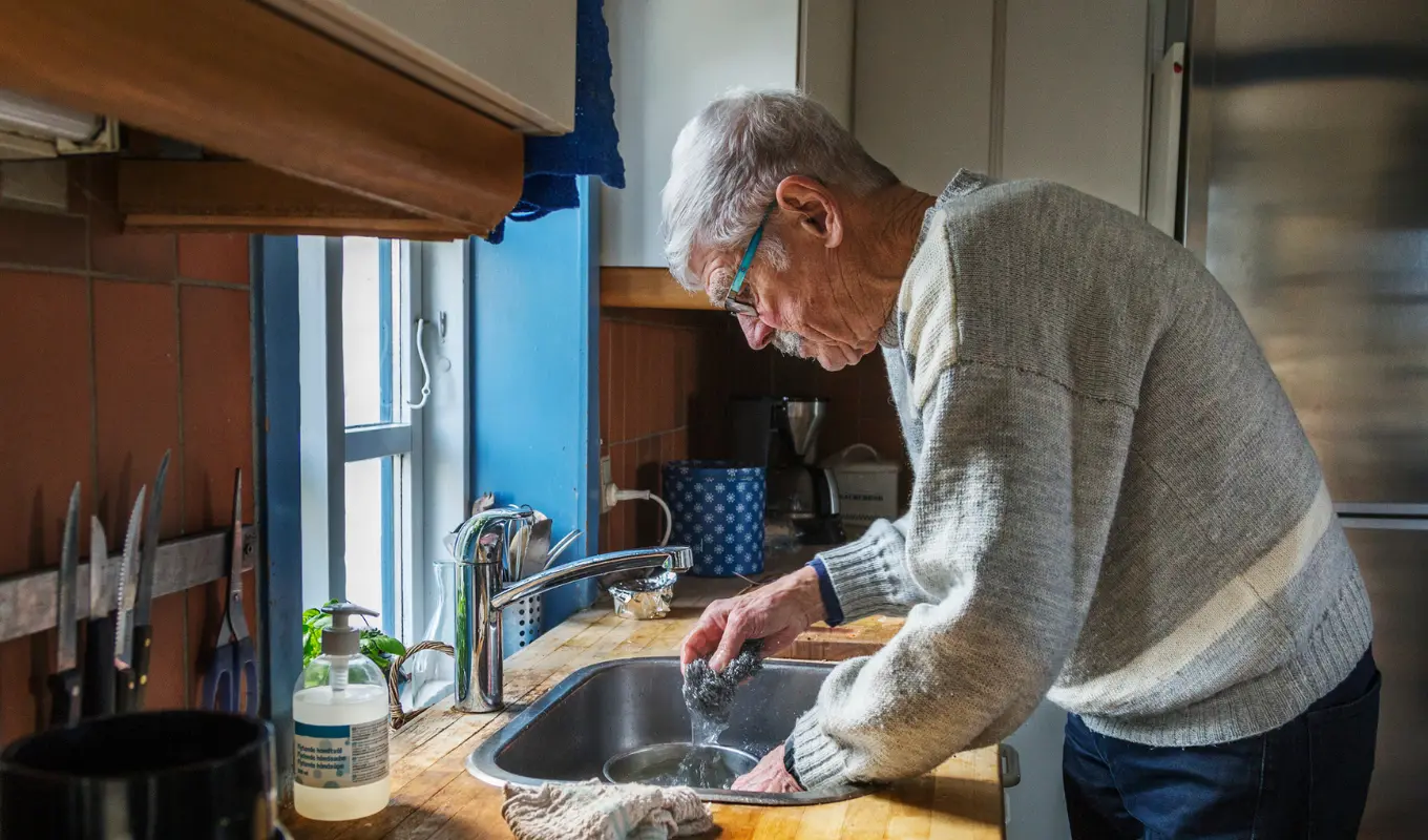 Äldre man diskar i sitt kök