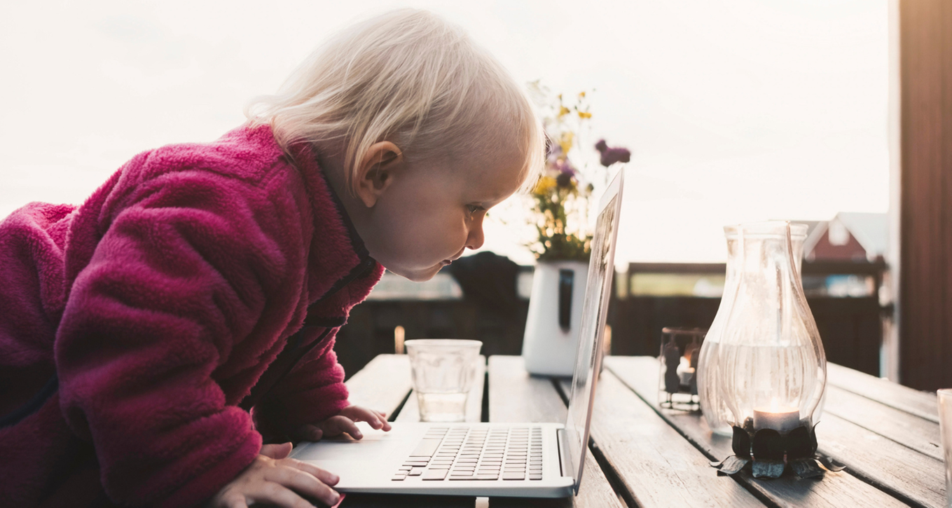 Litet barn tittar djupt in i en bärbar dator